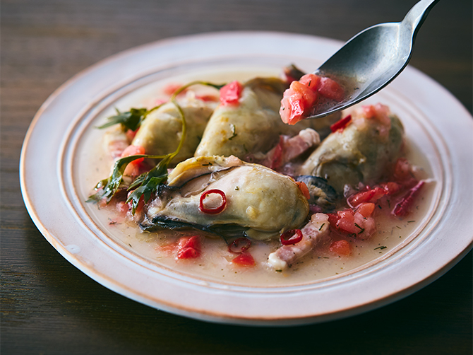 みじん切りのエシャロットに、赤ワインビネガーを合わせた爽やかなソースで味わう「牡蠣のコンフィ ミニョネットソース」。旨みとほどよい塩気のある熟成ベーコンが、アクセントに。