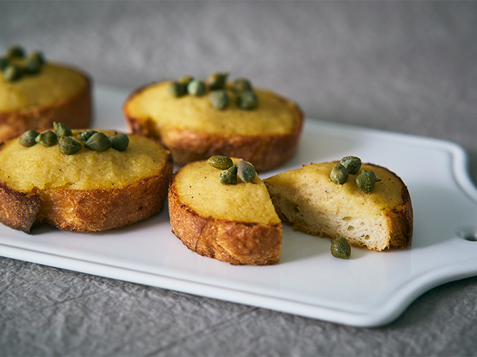 塩タラと玉ねぎを、白ワインと牛乳で煮て、ポテトと混ぜてペーストにした「バッカラマンテカート」。バゲットにのせて香ばしくトーストし、仕上げにケッパーをトッピング。