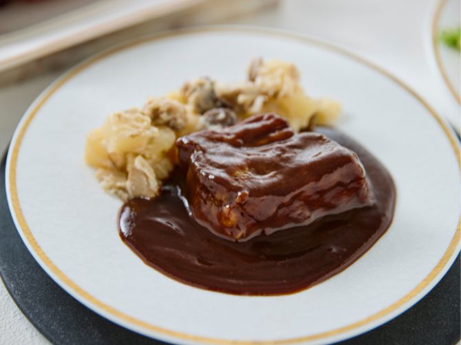 旨みのある黒毛和牛と風味豊かな赤ワインソースが堪能できる一品。付け合わせのフリカッセは、きのこの旨みに白ワイン、生クリームを加えて仕上げました。